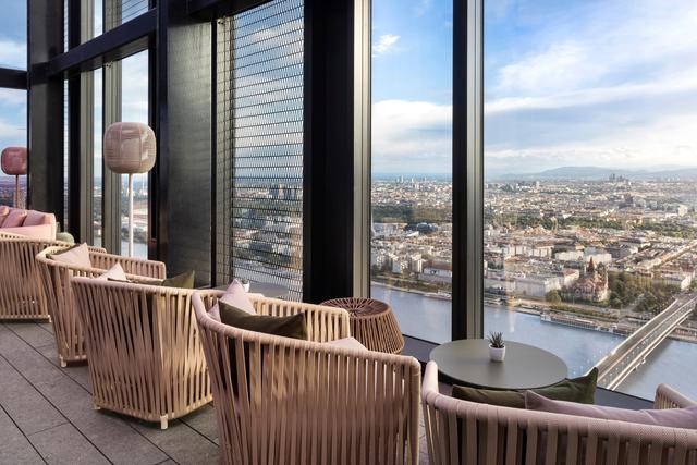 ein Raum mit Stühlen und einem Tisch und einem Blick auf eine Stadt